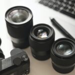Workplace with a modern equipment for photography. Mirrorless camera and prime lenses.